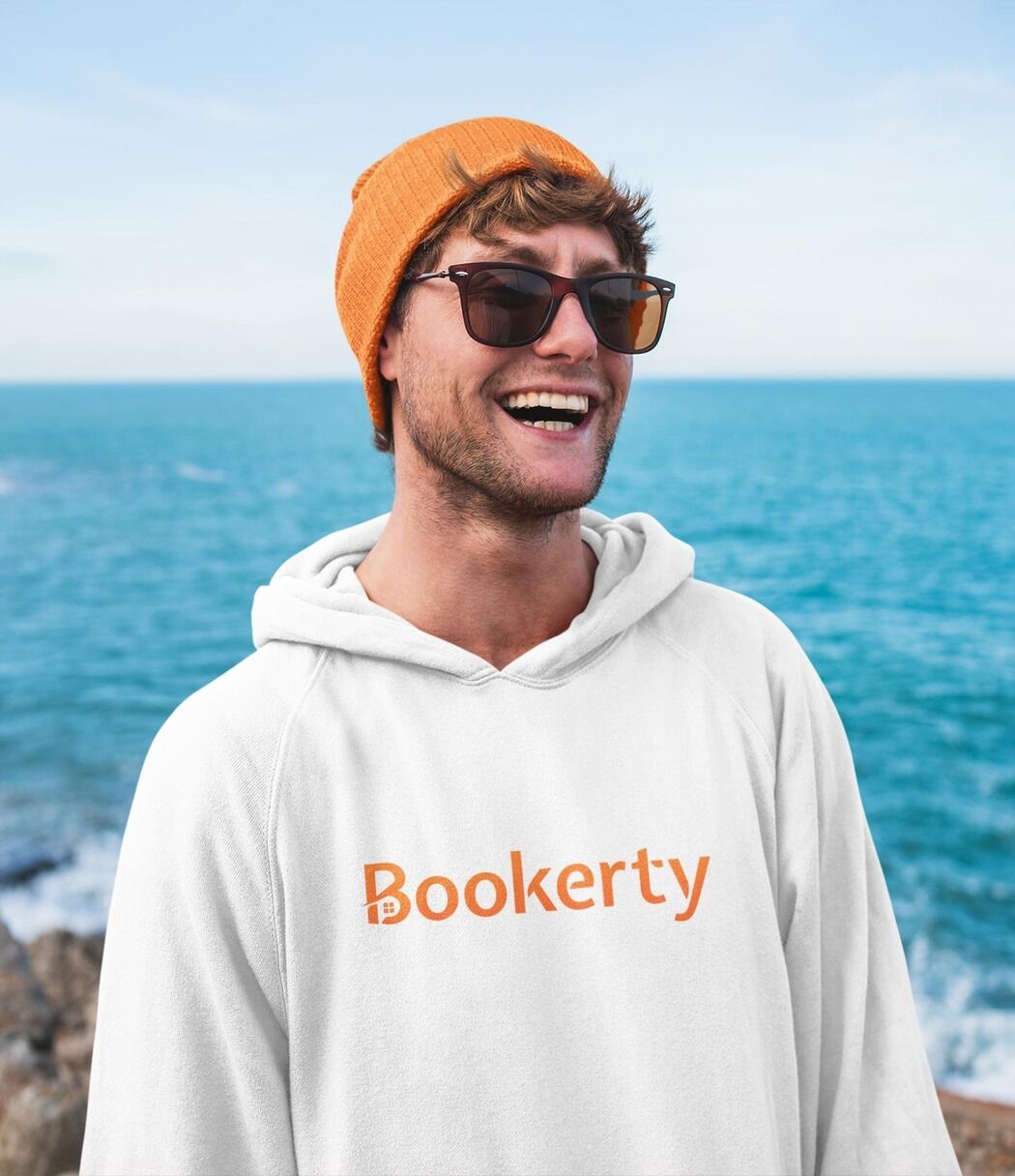 Smiling man with Bookerty hoodie in airport.